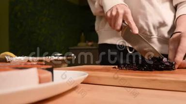 一个女孩的手特写在家厨房的一块木制砧板上小樱桃西红柿。家常菜